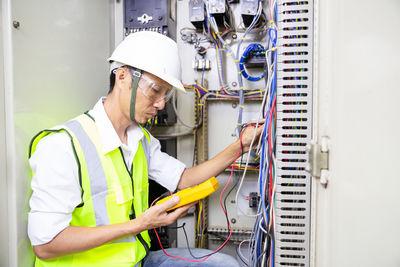 Electrician engineer work tester measuring voltage and current of power electric line