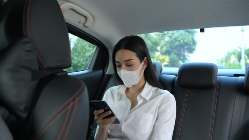 Woman using mobile phone in car