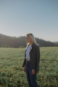 Woman standing on field against sky