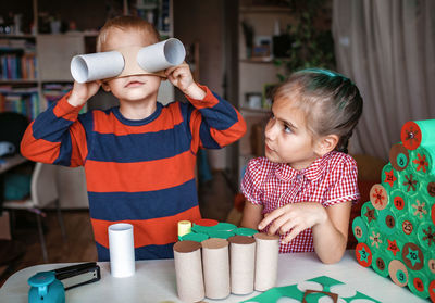 Kid making handmade advent calendar with toilet paper rolls. seasonal activity, family holidays