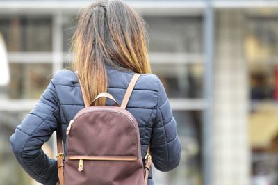 Rear view of woman carrying backpack while standing outdoors