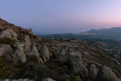 Scenic view of rocky mountains against clear sky during sunset