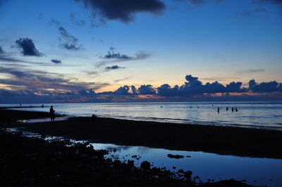 Scenic view of beach against cloudy sky