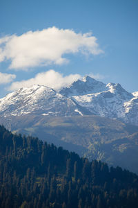 Snow peak mountain range glowing in sunlight with clear blue sky