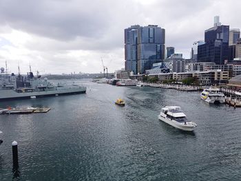 Boats in sea by buildings against sky