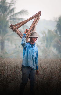 Man holding umbrella on field