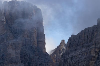 Low angle view of rocky mountains against sky