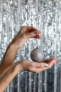 Female hands holding a shiny silver ball in celebration