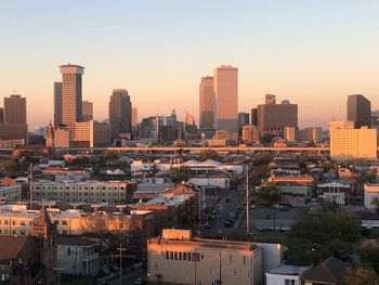 Modern buildings in city against sky during sunset