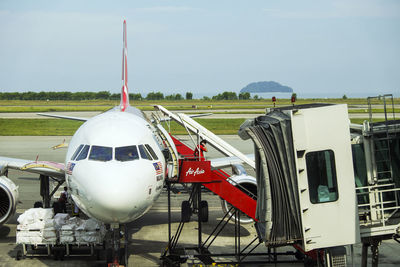 Airplane on airport runway against sky