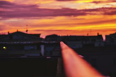 Close-up of hand against sky during sunset