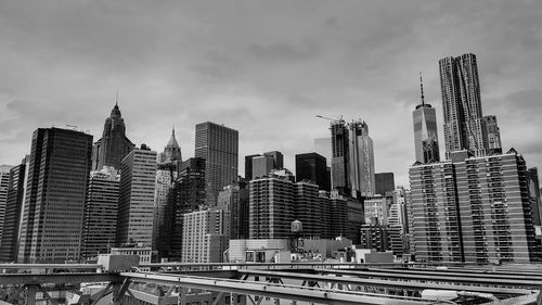 Low angle view of skyscrapers against cloudy sky