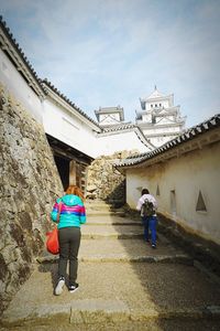 Rear view of people walking on building