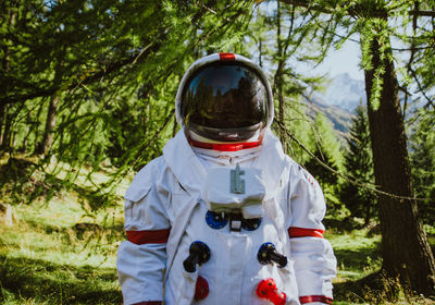 Close-up of man wearing spacesuit against trees