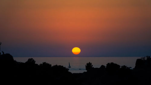 Scenic view of sea against romantic sky at sunset