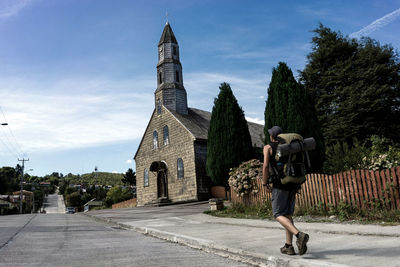 Rear view of man outside temple against building