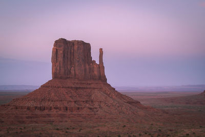 Rock formations on landscape against sky during sunset