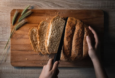 Directly above shot of person holding bread on cutting board