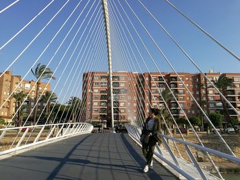 Rear view of man walking on footbridge
