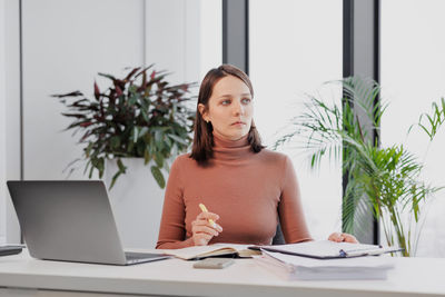 Young woman using laptop at office