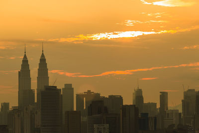 Modern buildings against sky during sunset