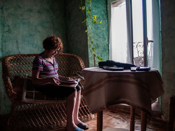 Woman reading book white sitting on seat at home