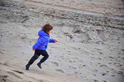 Full length of a boy playing on sand at beach