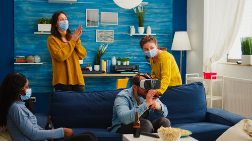 Man drinking beer while using virtual reality simulator at home