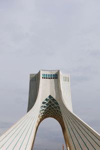 Low angle view of bridge against cloudy sky