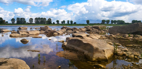 Panoramic view of rocks on shore against sky