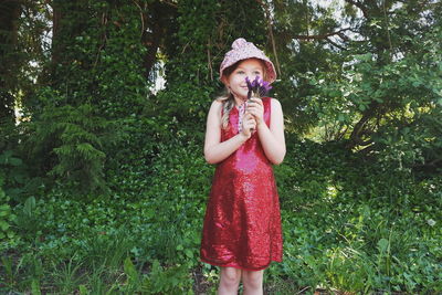 Cute girl holding flowers in forest