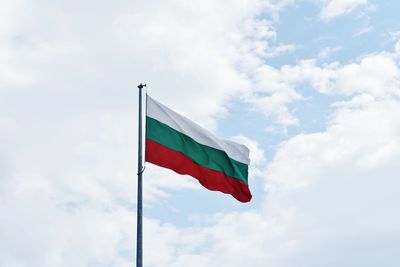 Low angle view of bulgarian flag against cloudy sky