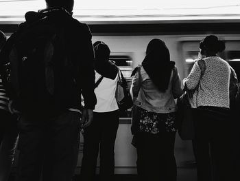 Rear view of people standing in corridor