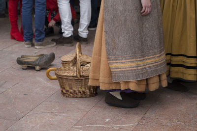 Low section of person in traditional clothing standing on footpath