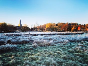 Scenic view of winter field against clear blue sky