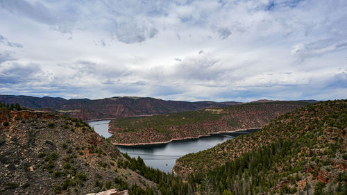 Scenic view of river amidst mountains against sky