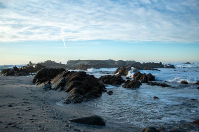 Rocks on beach against sky