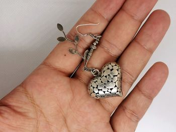 Close-up of hand holding earring