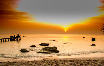 Silhouette people on beach during sunset