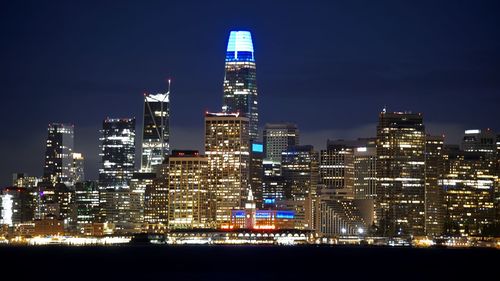 Illuminated buildings against sky at night