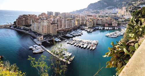 View of cityscape by sea against sky