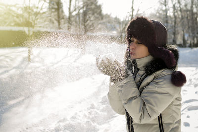 Young woman standing on snow covered landscape