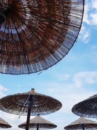 Low angle view of thatched roofs against sky