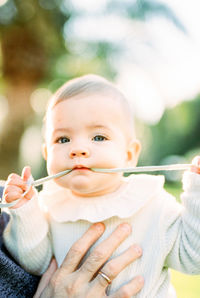 Close-up of young woman blowing bubbles while standing outdoors