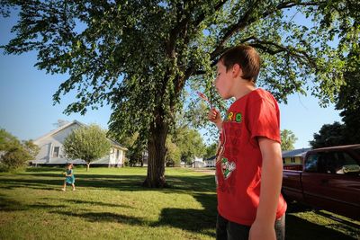 Happy boy playing in park against sky