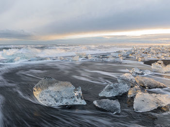 Aerial view of sea shore against sky during sunset