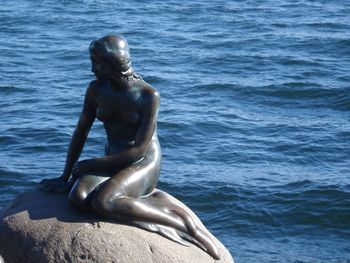 Close-up of shirtless statue against water