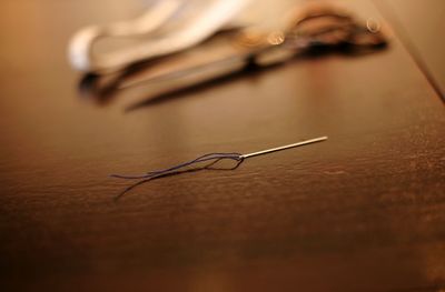 Close-up of needle on table