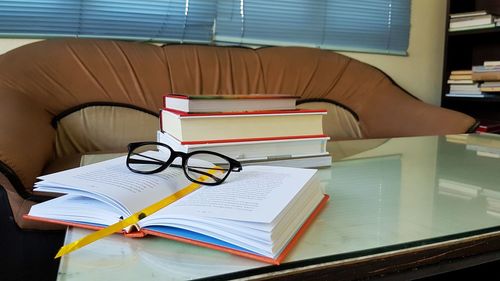 Close-up of eyeglasses and stacked books on table