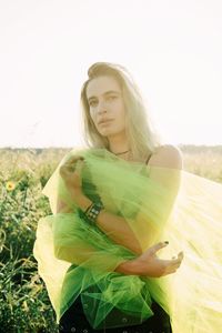 Portrait of woman holding netting while standing against plants